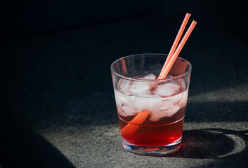 Red Cocktail Lemonade Glass Ice Cubes Straws Isolated Sun Summer Drink Black background Stone