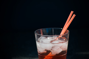 Red Cocktail Lemonade Glass Ice Cubes Straws Isolated Sun Summer Drink Black background Stone