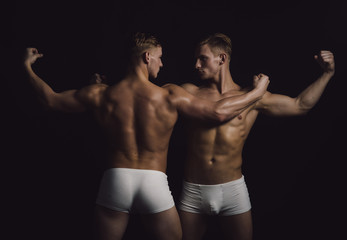 Fototapeta na wymiar sportsmen with muscular body. sportsmen twins in bodybuilder pose.