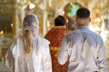 Back view of bride and groom on orthodox wedding ceremony in the church