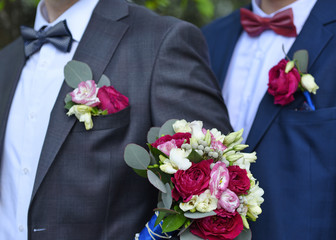 Wedding bouquet against the background of the groom and the witness.