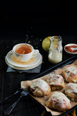 Sweet buns with a block and cinnamon on a dark background