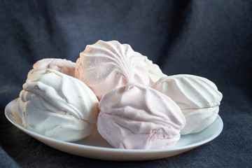 food, confection and sweets concept - close up of zephyr or marshmallow dessert on plate