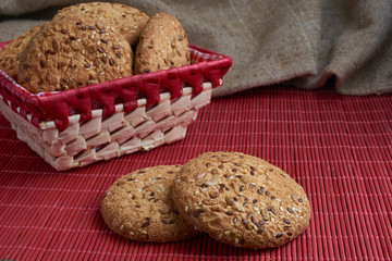 Savory cookies sprinkled with sesame seeds, sunflower on table and burlap background
