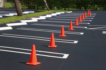 Orange Caution Cones Lined Up along Several Spaces in a Church Parking Lot in a Sunny Afternoon