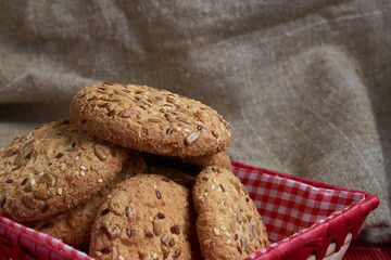 Savory cookies sprinkled with sesame seeds, sunflower on table and burlap background