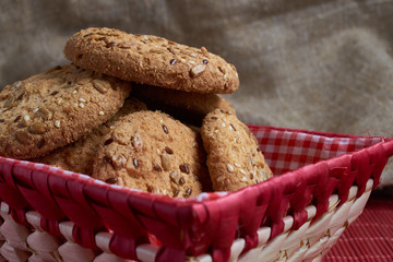Savory cookies sprinkled with sesame seeds, sunflower on table and burlap background