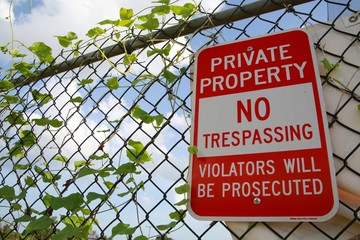 Private Property No Trespassing Violators Will Be Prosecuted Red and White Sign on Chain Link Fence...
