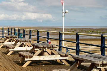 Cafe with rustic wooden tables on pier in Southport, Britain