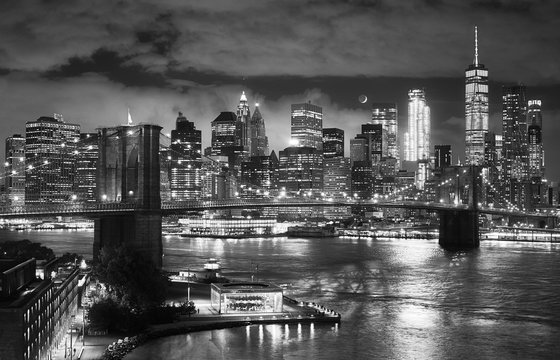 Black and white picture of the Brooklyn Bridge and Manhattan seen from Dumbo at night, New York City, USA.