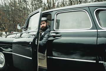 Bearded man in car. Retro collection car and auto repair by mechanic driver. Escort man or security...