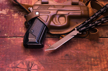 A knife and a gun. A pistol in a leather holster.