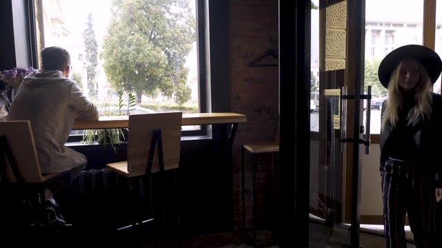 A guy in a cafe meets his friend