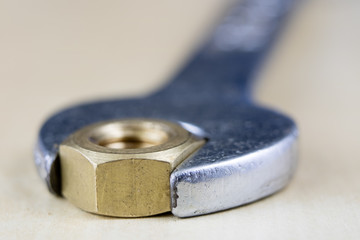 Metric screw and key on a wooden table. Mechanical accessories in the locksmith workshop.