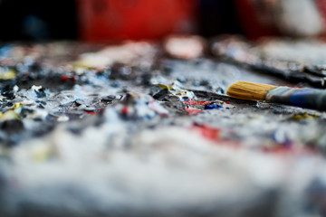Fototapeta premium Palette with different paints and paintbrush in art studio