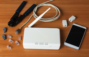 Smartphone, components for connecting a router and a crimper, on table