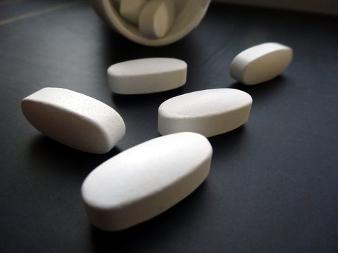 White pills in blister pack close-up on dark