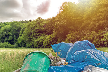 pile of plastic garbage on meadow near forest. Concept: ecology problems and pollution