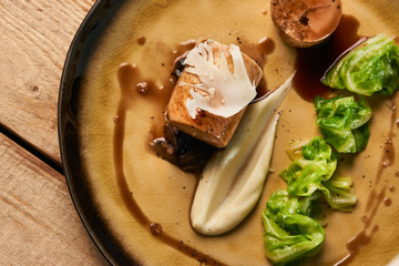 Delicious homemade meat sausage and boiled cabbage with sauce on a plate, close-up.