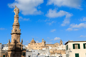 Italy, SE Italy. Ostuni. Statue of Saint Oronzo looks down on the square of Italian town of Ostuni which is known as the 'White City' in Italy.