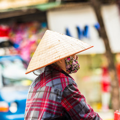 Woman in the vietnamese hat on a city street in Hanoi, Vietnam. Close-up.