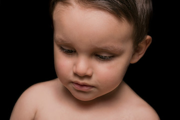 Portrait of beautiful little boy portrait on black background