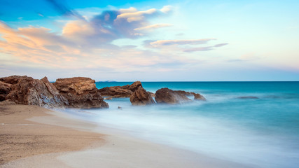 Rocks on a sandy beach in Miami Platja, Catalunya, Spain. Copy space for text