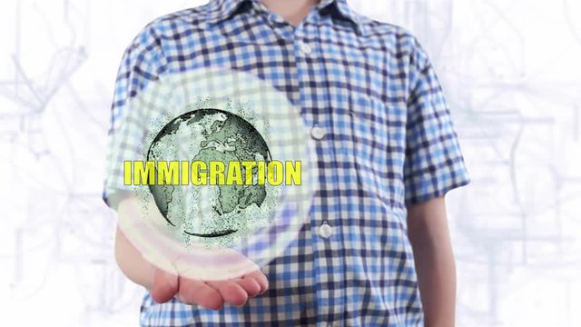 Young man shows a hologram of the planet Earth and text Immigration. Boy with future technology 3d projection on a modern white digital background