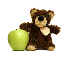 Toy bear on white background with green apple.      