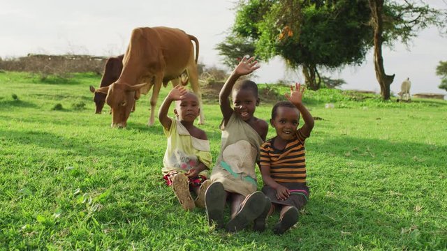 Maasai children waving hands