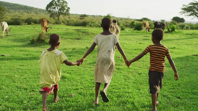 Children holding hands and walking on a field
