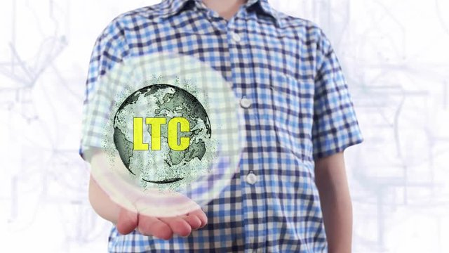 Young man shows a hologram of the planet Earth and text LTC. Boy with future technology 3d projection on a modern white digital background
