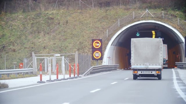Truck on highway drive in to a tunnel slow motion 4K