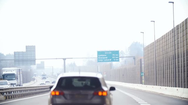 Driving on motorway with focus on green exit sign 4K