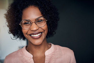 African businesswoman standing in a modern office smiling confidently