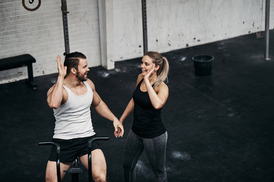 Fit people high fiving together after a stationary bike workout