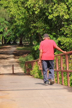Man in red shirt walinking on path 