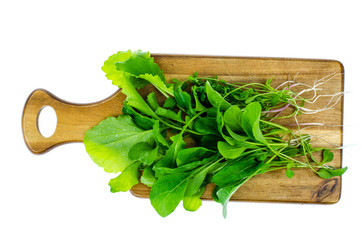 Ingredients for salad from green leaves of garden herbs on cutting board