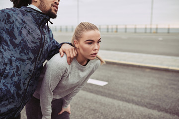 Sporty young couple taking a break together while jogging