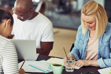 Smiling group of diverse colleagues working around an office tab