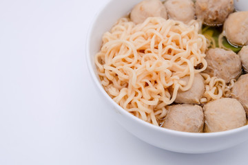 Close up and top view: Instant noodles with meat balls in white bowl and isolated on white background. Spicy tasty, street food.