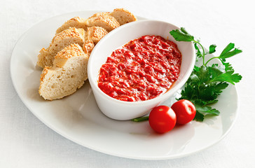 vegetable caviar made of roasted sweet peppers served with bread, tomatoes and parsley