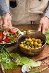 Woman hands holds new potato cooked in pot and served with olive oil, butter, herbs and onion sprouts. Raw vegan vegetarian healthy food. Organic farm products