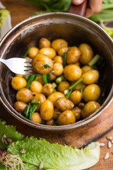 New potato cooked in pot and served with olive oil, butter, herbs and onion sprouts. Raw vegan vegetarian healthy food. Organic farm products