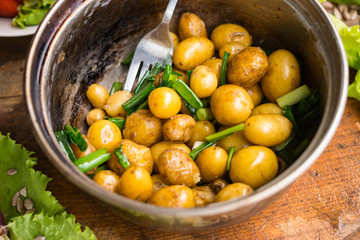 New potato cooked in pot and served with olive oil, butter, herbs and onion sprouts. Raw vegan vegetarian healthy food. Organic farm products