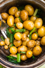 New potato cooked in pot and served with olive oil, butter, herbs and onion sprouts. Raw vegan vegetarian healthy food. Organic farm products
