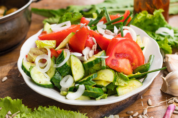 Fresh vegetables Greek salad with tomatoes, cucumbers, onion slices and sprouts. Served with olive oil. Raw vegan vegetarian healthy food