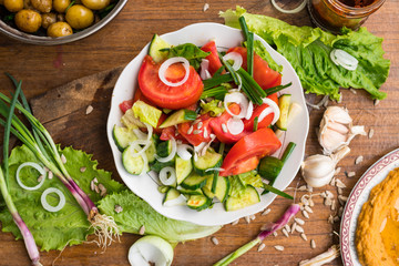 Fresh vegetables Greek salad with tomatoes, cucumbers, onion slices and sprouts. Served with olive oil. Raw vegan vegetarian healthy food