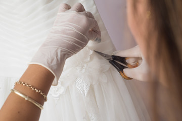 Obraz na płótnie Canvas Hands works on wedding dress repair