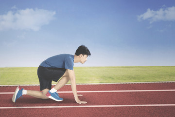 Young man in start position to run